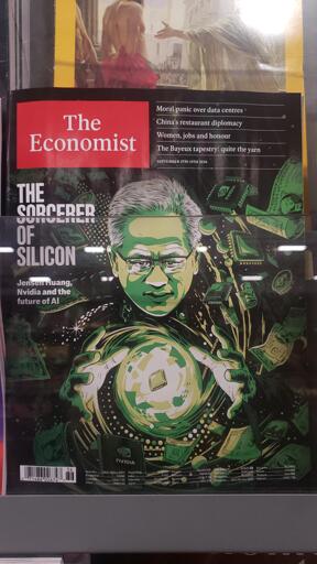 Photo of The Economist magazine. The front cover shows a green monochrome graphic of Jensen Huang with a swirling ball between his hands with money and Nvida chips flying around. The main headline is, "The Sourcer of Silicon: Jensen Huang, Nvidia and the future of AI". Other headlines listed are, "Moral panic over data centres", "China's restaurant diplomacy", "Women, jobs and honour", and "The Bayeux tapestry: quite the yarn"